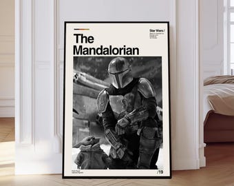 May include: Framed black and white poster of The Mandalorian and Grogu from Star Wars. The poster displays the title "The Mandalorian" in bold text, with the Star Wars logo. The image shows the Mandalorian and Grogu in a detailed, action pose.