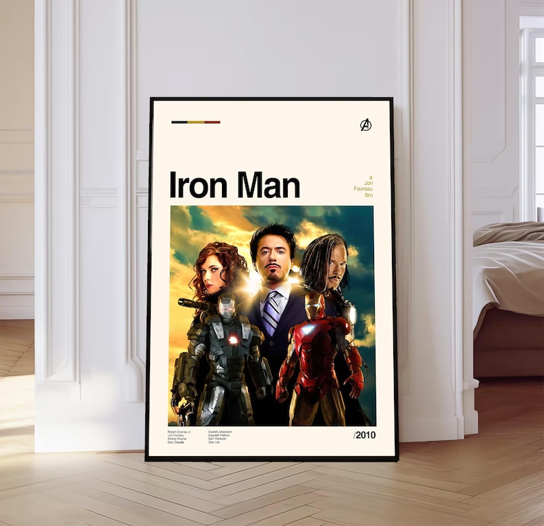 May include: A framed poster featuring the movie "Iron Man" with the title in bold black letters. The poster showcases several characters from the film, including Iron Man in his red and gold suit. The background has a sunset-like sky.