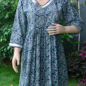 Puede incluir: Vestido largo y fluido con estampado de cachemir en azul marino, verde y blanco. El vestido presenta un escote en V y mangas largas con ribete blanco. La tela parece ligera, ideal para climas c&aacute;lidos. Mide aproximadamente 140 cm.