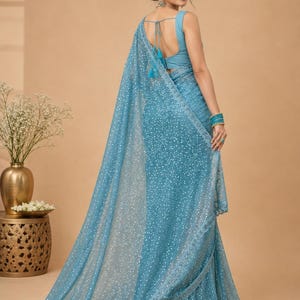 Elegant pastel blue saree with all over shimmer detailing and designer lace border