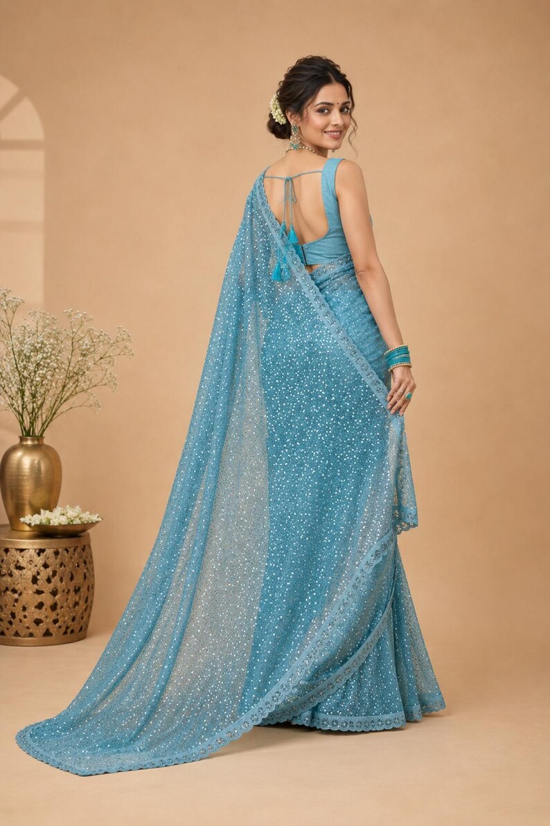 Elegant pastel blue saree with all over shimmer detailing and designer lace border