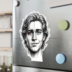 Könnte beinhalten: Ein schwarz-weißer Aufkleber mit einer geteilten Gesichtsillustration. Eine Seite zeigt ein weinendes Gesicht mit einem roten Auge, die andere ein lächelndes Gesicht mit einem blauen Auge. Der Aufkleber befindet sich auf einem silbernen Kühlschrank.
