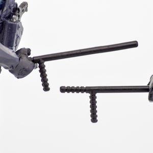May include: Two black batons, held by figures in tactical gear, are shown against a white backdrop. The batons have a cylindrical shaft and a T-shaped handle. The figures are wearing blue and black uniforms.