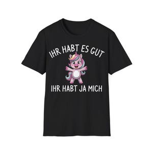 May include: Black t-shirt featuring a colorful unicorn graphic with the text "IHR HABT ES GUT, IHR HABT JA MICH" in white. The unicorn has a pink body, a yellow horn, and a rainbow mane.