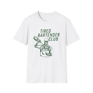 May include: White t-shirt with a green graphic of a skeleton bartender pouring a drink. The text "Tired Bartender Club" is above the illustration. The design features a skeleton wearing an apron and holding a bottle and a glass.