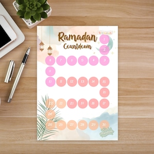 May include: Ramadan Countdown calendar with a watercolor design. The calendar features a series of pink circles numbered 1-30, with the word "Ramadan" in gold script. Decorative elements include lanterns and palm fronds.