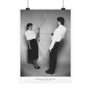 Könnte beinhalten: Schwarz-Weiß-Druck mit zwei Personen mit Pfeil und Bogen. Eine Person hält den Bogen, die andere hat den Pfeil gespannt. Der Druck enthält den Text "MARINA ABRAMOVIĆ AND ULAY REST ENERGY 1980".