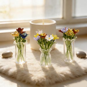 Pu&ograve; includere: Un set di tre tazze in ceramica con finitura opaca e macchiettata. Le tazze sono nei toni del crema, grigio chiaro e grigio scuro. Ogni tazza ha un design semplice e minimalista e un manico arrotondato.