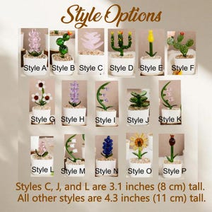 May include: A collection of sixteen miniature glass plants in white pots labeled Style A through P. Styles C, J, and L are 3.1 inches tall, while all other styles are 4.3 inches tall. The plants feature various shapes, colors, and floral designs.
