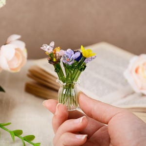 Pu&ograve; includere: Una tazza di ceramica bianca con manico nero e la scritta "But First, Coffee" in grassetto nero. La tazza &egrave; posta su uno sfondo sfocato, che suggerisce un'atmosfera accogliente.