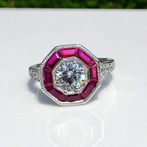 May include: A white ceramic mug with a black handle and the text "But First, Coffee" in a bold, black font. The mug is set against a blurred background, suggesting a cozy setting. The mug appears to be approximately 4 inches tall.