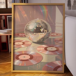Könnte beinhalten: Ein gerahmter Druck mit einer Discokugel und rosa Schallplatten. Das Kunstwerk hat einen goldenen Rahmen und befindet sich in einem Raum mit Sofa, Stehlampe und Fenster. Der Stil ist retro und stilvoll.