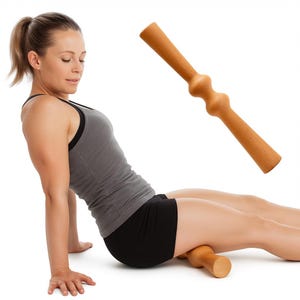 Pode incluir: Um rolo de massagem de madeira castanha clara com formato cil&iacute;ndrico e extremidades arredondadas. O rolo est&aacute; sendo usado na perna de uma pessoa. A pessoa est&aacute; usando uma regata cinza e shorts pretos.