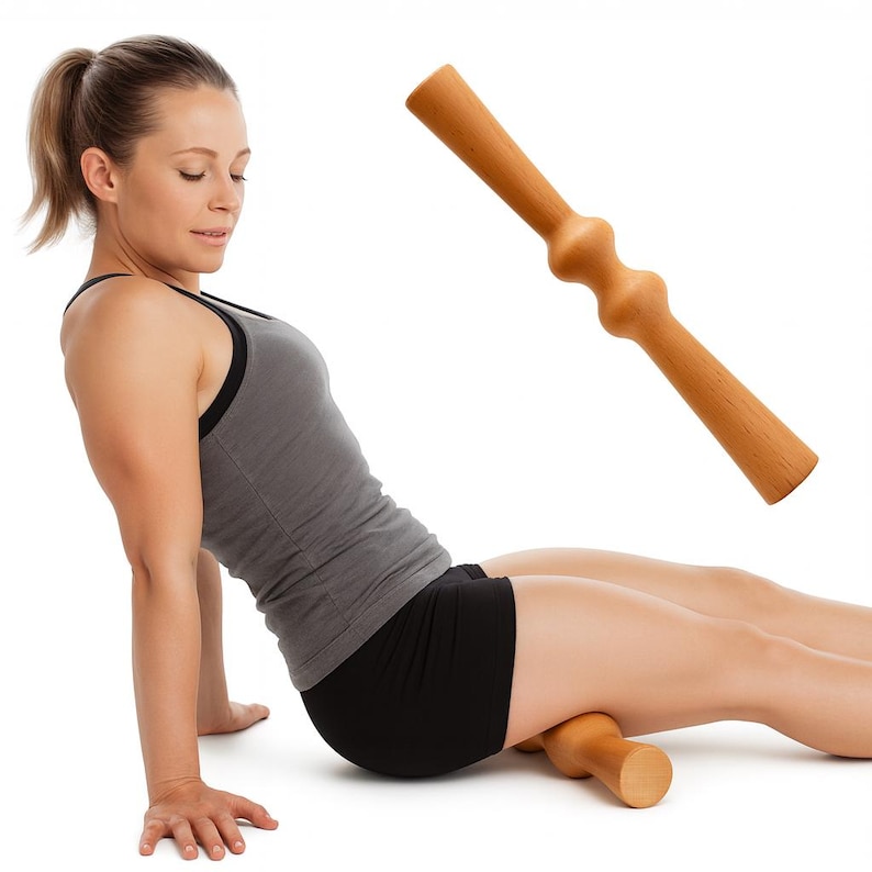 Pode incluir: Um rolo de massagem de madeira castanha clara com formato cil&iacute;ndrico e extremidades arredondadas. O rolo est&aacute; sendo usado na perna de uma pessoa. A pessoa est&aacute; usando uma regata cinza e shorts pretos.