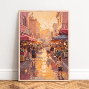 May include: A framed oil painting depicts a bustling outdoor market scene. The artwork features a warm color palette of oranges, yellows, and reds, with figures of people walking along a street lined with market stalls under awnings. The sun is shining brightly.