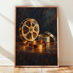 Könnte beinhalten: Ein vertikaler rechteckiger Druck, der eine goldene Filmrolle zeigt, von der sich ein Filmstreifen über eine dunkle, strukturierte Oberfläche abwickelt. Neben der Rolle befinden sich zwei metallische Filmdosen, eine offen und eine geschlossen.