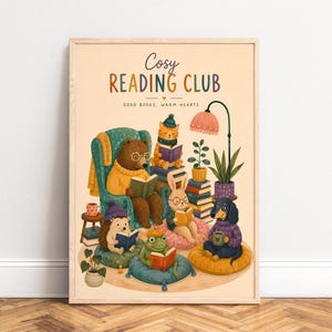 Könnte beinhalten: Ein gerahmter Kunstdruck mit dem Titel Cosy READING CLUB GOOD BOOKS, WARM HEARTS, der einen Bären, eine Katze, einen Hasen, einen Igel, einen Frosch und einen Hund beim Lesen auf Kissen und Stühlen in einem warmen, bunten Raum zeigt.