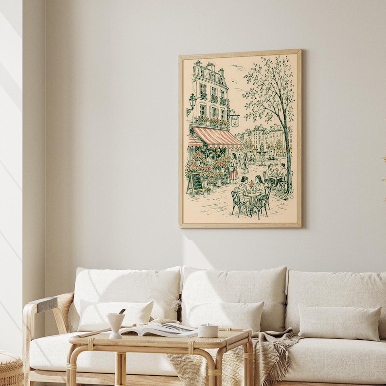 Puede incluir: Una l&aacute;mina de arte enmarcada con un dibujo lineal detallado de una escena callejera parisina. La ilustraci&oacute;n muestra un caf&eacute; con mesas al aire libre, una florister&iacute;a con un toldo a rayas y un &aacute;rbol alto, en tonos verdes y rosados.