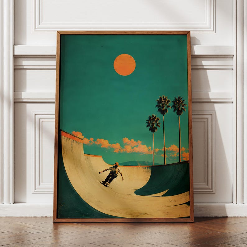 May include: A framed art print depicts a skateboarder in a skate bowl under a teal sky with an orange sun and palm trees. The artwork has a vintage, retro aesthetic with a warm color palette. The wooden frame adds a classic touch to the overall design.