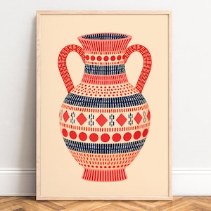 May include: A framed art print featuring a two-handled vase illustration. The vase is decorated with horizontal bands of red circles, navy blue dashes, and red diamonds against a light cream background, all enclosed in a light wood frame.
