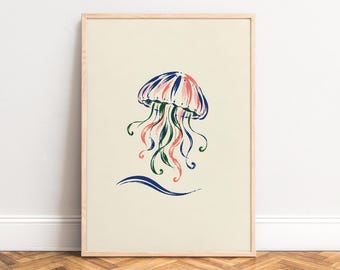 May include: A framed wall art print featuring a stylized jellyfish illustration in shades of blue, pink, and green on a cream background. The jellyfish has a rounded bell and flowing tentacles, with a single blue wave graphic positioned below it.