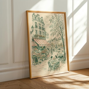 Puede incluir: Una l&aacute;mina de arte enmarcada con un dibujo lineal detallado de una escena callejera parisina con una florister&iacute;a, mesas de caf&eacute; al aire libre y personas. La ilustraci&oacute;n incluye un cartel que dice "FLEURS A CAFE" y una pizarra con texto.