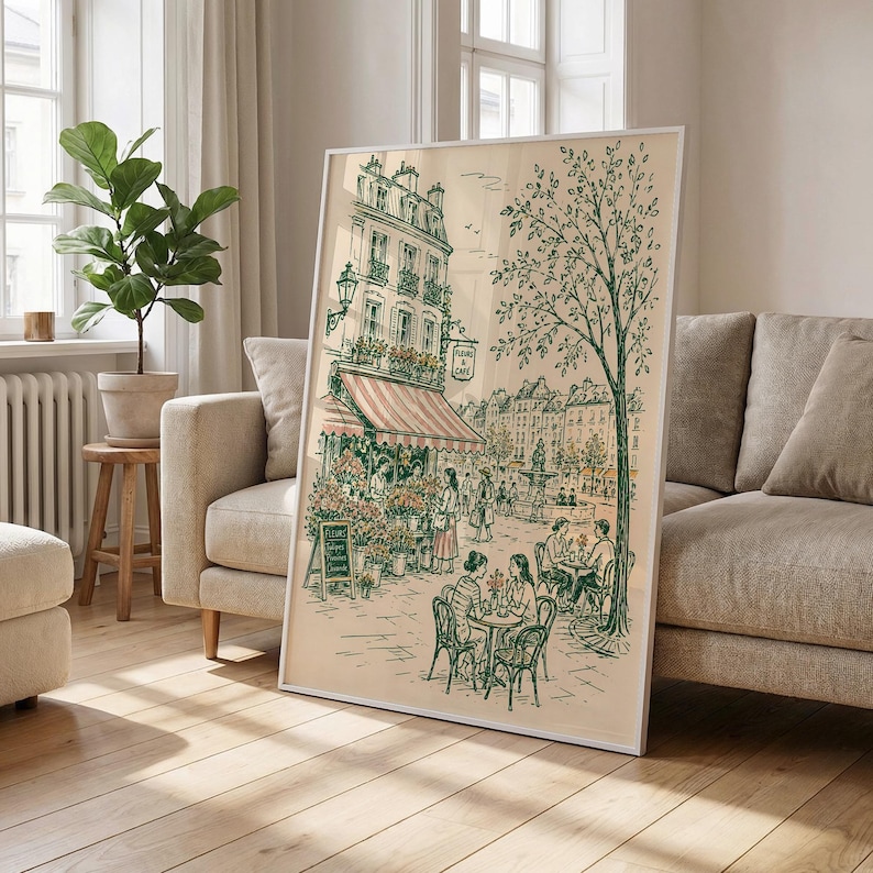 Puede incluir: Una l&aacute;mina de arte enmarcada con un dibujo lineal detallado en verde y crema de una escena callejera parisina. La ilustraci&oacute;n muestra un edificio de varias plantas con un toldo a rayas, una florister&iacute;a, un gran &aacute;rbol y personas sentadas.