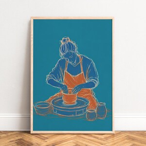 May include: Framed art print featuring a teal background with a line drawing of a person working on a pottery wheel. The person wears an orange apron and is creating a clay pot. Additional pottery pieces are visible.