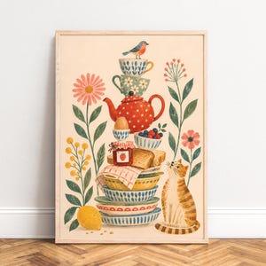 May include: A framed vertical art print featuring a stack of colorful patterned bowls, a red polka-dot teapot, a jar of strawberry jam, toast, and an egg. A small bird sits on top, while a ginger tabby cat looks up from the side, surrounded by flowers.