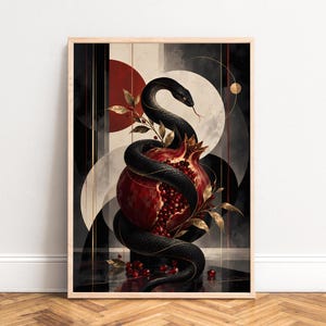 Könnte beinhalten: Ein gerahmter vertikaler Kunstdruck, der eine schwarze Schlange zeigt, die sich um einen aufgeschnittenen Granatapfel mit sichtbaren roten Kernen windet. Der Hintergrund besteht aus abstrakten geometrischen Formen in Schwarz, Weiß und Rot.