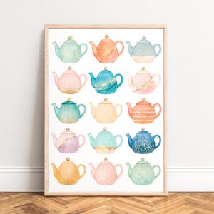 Op de afbeelding: Een ingelijste wandkunstprint met een raster van vijftien aquarel theepotten in diverse pastel- en levendige kleuren, waaronder tinten blauw, roze, oranje en groen. Elke theepot heeft een uniek patroon en een goudkleurig deksel.