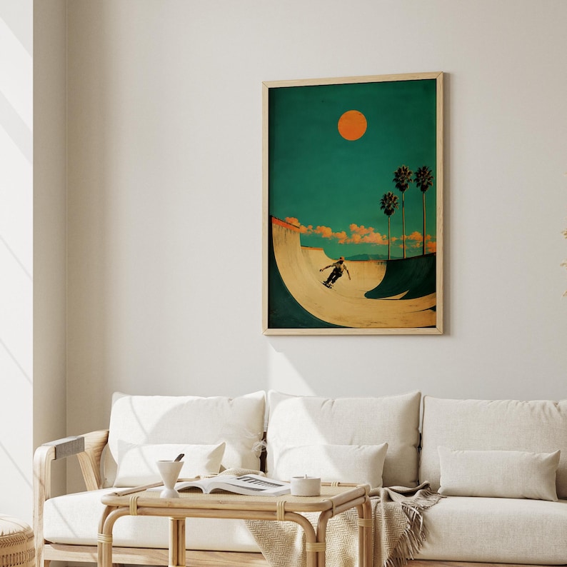 May include: A framed art print depicts a skateboarder in a skate bowl under a bright orange sun. The background is teal with palm trees and clouds. The artwork has a vintage, retro style.