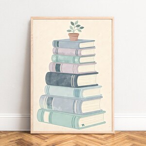 Peut inclure: Impression d'art encadrée représentant une pile de livres aux tons bleus, verts et violets. Un petit pot de plante est posé au sommet. L'œuvre d'art est de style aquarelle douce, sur fond crème.