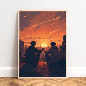Op de afbeelding: Een ingelijste verticale kunstdruk met twee figuren die op een dak zitten en elkaars hand vasthouden terwijl ze naar een zonsondergang over een stad kijken. De scène is uitgevoerd in warme oranje en donkere tinten met gebouwensilhouetten.