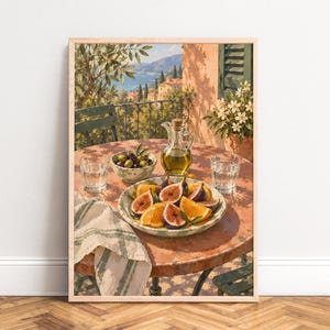Può includere: Una stampa artistica incorniciata raffigurante un tavolo esterno soleggiato con un piatto di fichi e arance a fette, una ciotola di olive, una caraffa di vetro con olio d'oliva e due bicchieri d'acqua. Un panno a motivi pende dal tavolo.