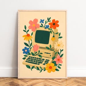 Puede incluir: Una impresión artística enmarcada que presenta una computadora vintage rodeada de flores coloridas. La computadora es beige con una pantalla verde y un teclado. Las flores incluyen flores rosas, naranjas, amarillas y azules, con hojas verdes. La obra de arte está sobre un fondo beige claro.