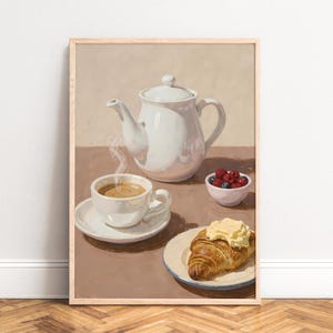 Könnte beinhalten: Gerahmter Kunstdruck eines Stilllebens mit weißer Teekanne, dampfender Kaffeetasse, kleiner Schale mit Beeren und Croissant mit Butter. Die Farbpalette ist sanft, mit warmen Braun- und Weißtönen.