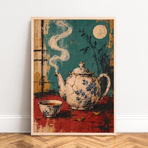 Op de afbeelding: Een ingelijste kunstdruk met een gebarsten witte theepot met blauwe bloemmotieven en een bijpassend theekopje. Stoom stijgt op uit de theepot tegen een groenblauwe achtergrond met een volle maan en donkere silhouetten van takken.