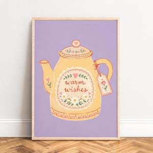 Peut inclure: Une affiche murale encadrée représentant une théière jaune sur un fond violet clair. La théière est ornée de motifs floraux, d'un petit cœur et du texte "warm wishes" en écriture rouge, avec une étiquette assortie attachée à la poignée.