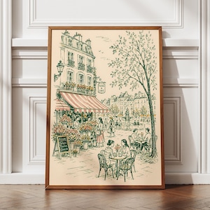 Puede incluir: Una l&aacute;mina art&iacute;stica enmarcada con un dibujo lineal de una escena callejera parisina con una florister&iacute;a y una cafeter&iacute;a. La ilustraci&oacute;n incluye un edificio con un toldo a rayas, un &aacute;rbol grande y personas sentadas. El texto dice Fleurs & Caf&eacute;.