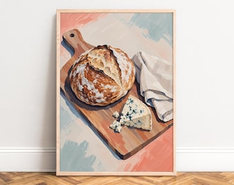May include: A framed art print featuring a round, crusty loaf of sourdough bread and a wedge of blue cheese on a wooden cutting board. A folded white cloth napkin sits beside the food, all set against a soft, painterly background of pastel tones.