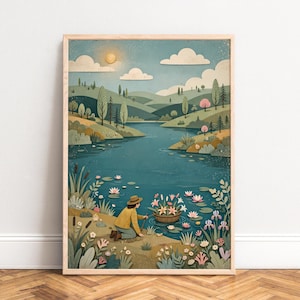 Puede incluir: Una impresión de arte mural enmarcada que muestra a una persona con camisa amarilla y sombrero marrón arrodillada junto a un lago azul. La escena presenta colinas verdes, un sol pálido, nubes blancas y una cesta con flores rosas en el agua.