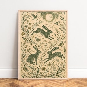 Può includere: Una stampa artistica verticale incorniciata con uno sfondo color crema e illustrazioni a inchiostro verde scuro di tre lepri, vari fiori di campo, erbe, farfalle e uccelli, disposti sotto una luna circolare e un cielo stellato.