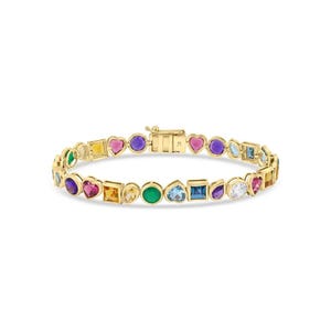 May include: A gold bracelet featuring a variety of colorful gemstones in different shapes, including hearts, squares, and circles. The gemstones are set in a gold chain with a clasp closure. The bracelet is displayed against a white background.