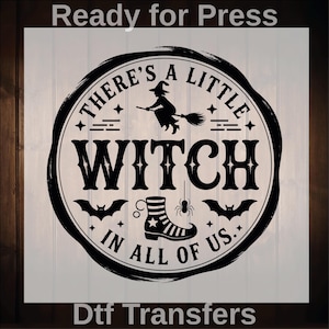 May include: Black and white Halloween-themed graphic with the text "THERE'S A LITTLE WITCH IN ALL OF US." The design includes a witch on a broom, bats, a boot, and a spider. The words "Ready for Press" and "Dtf Transfers" are also present.