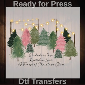 May include: A digital transfer design featuring a forest of Christmas trees in shades of green and pink, with string lights overhead. The text reads "Decked in Joy, Rooted in Love, A Forest of Christmas Cheer." The words "Ready for Press" and "Dtf Transfers" are also visible.