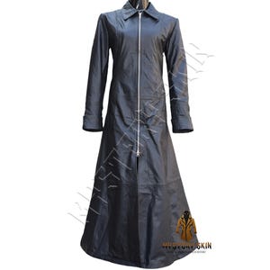 Puede incluir: Un abrigo largo de cuero negro con cierre de cremallera completa. El abrigo presenta un cuello con solapas, mangas largas con puños abotonados y una falda acampanada. El abrigo está diseñado para llegar a los tobillos.