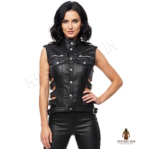 May include: A black leather vest with a high collar, button-up front, and side cutouts. The vest has two zippered pockets and silver hardware. The model is wearing black leather pants. The vest is from Mystery Skin.