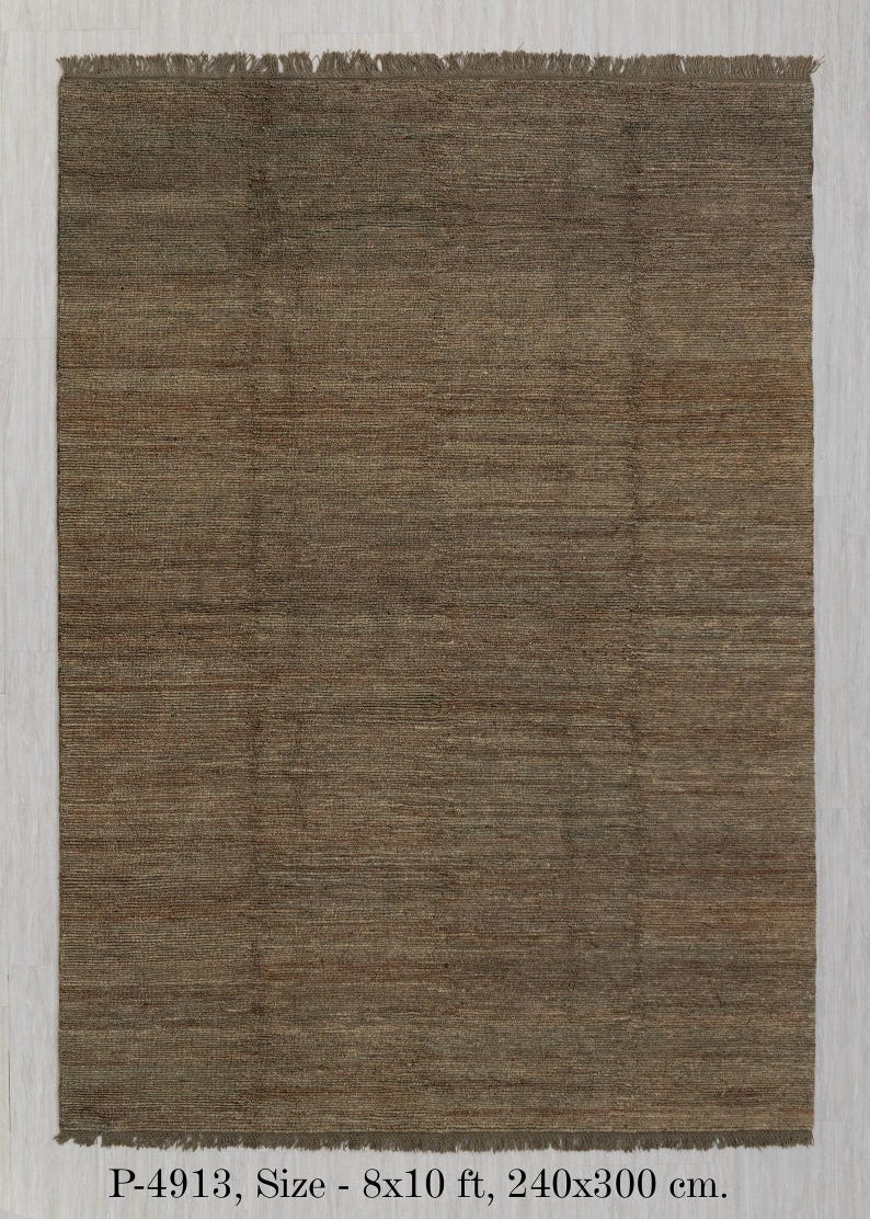 May include: A brown rectangular rug with a textured surface and fringed edges. The rug measures 240x300 cm. The rug has a simple, neutral design, suitable for various interior styles. The rug's color is a warm, earthy tone.