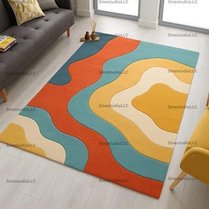 Könnte beinhalten: Ein rechteckiger Teppich mit einem lebendigen, abstrakten Design. Der Teppich hat wellenförmige Muster in Orange, Türkis, Gelb und Creme. Er liegt auf einem hellen Holzboden, mit einem grauen Sofa und einem gelben Stuhl im Hintergrund.